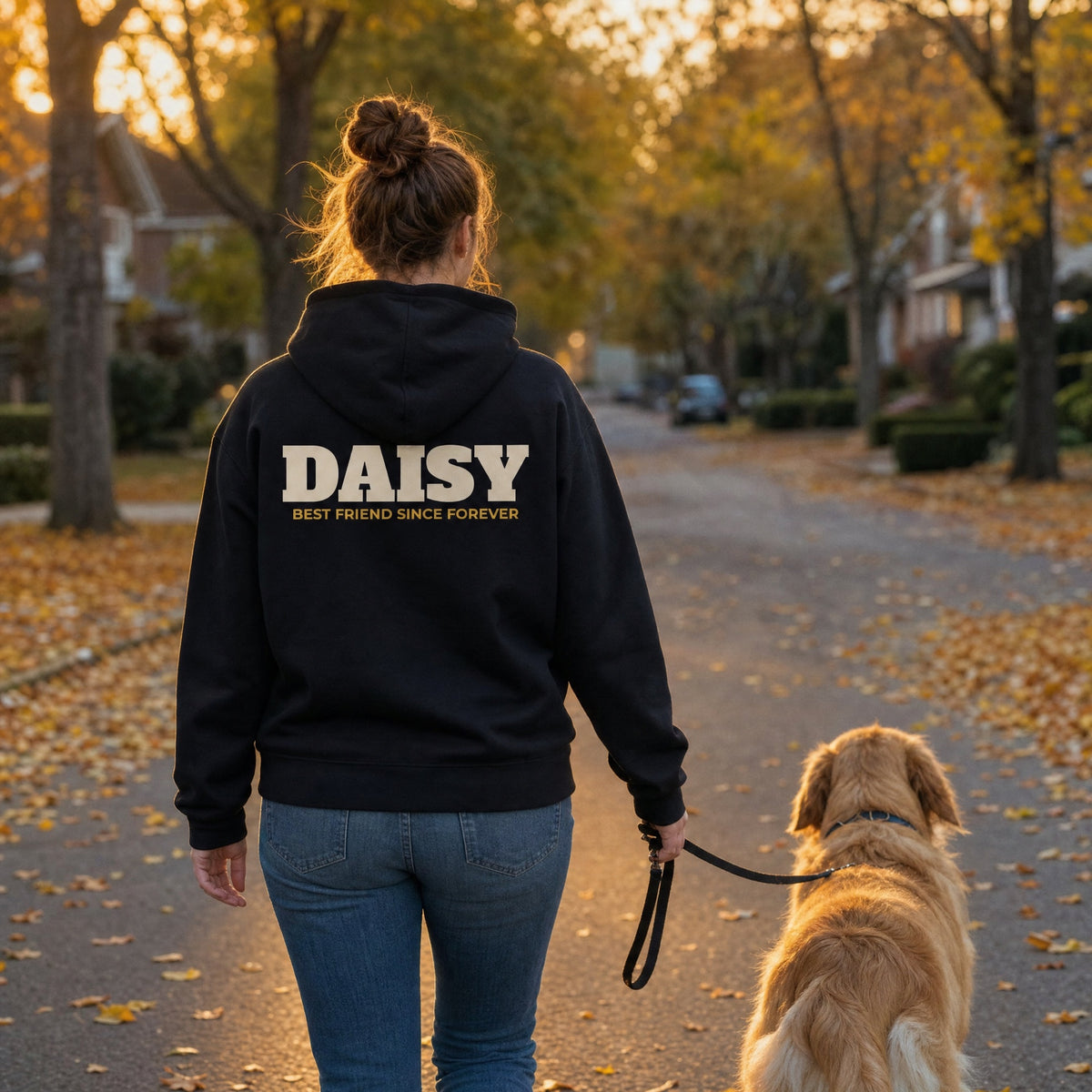 AI-generated example photo: back of the custom pet hoodie with the name DAISY, walking a golden retriever