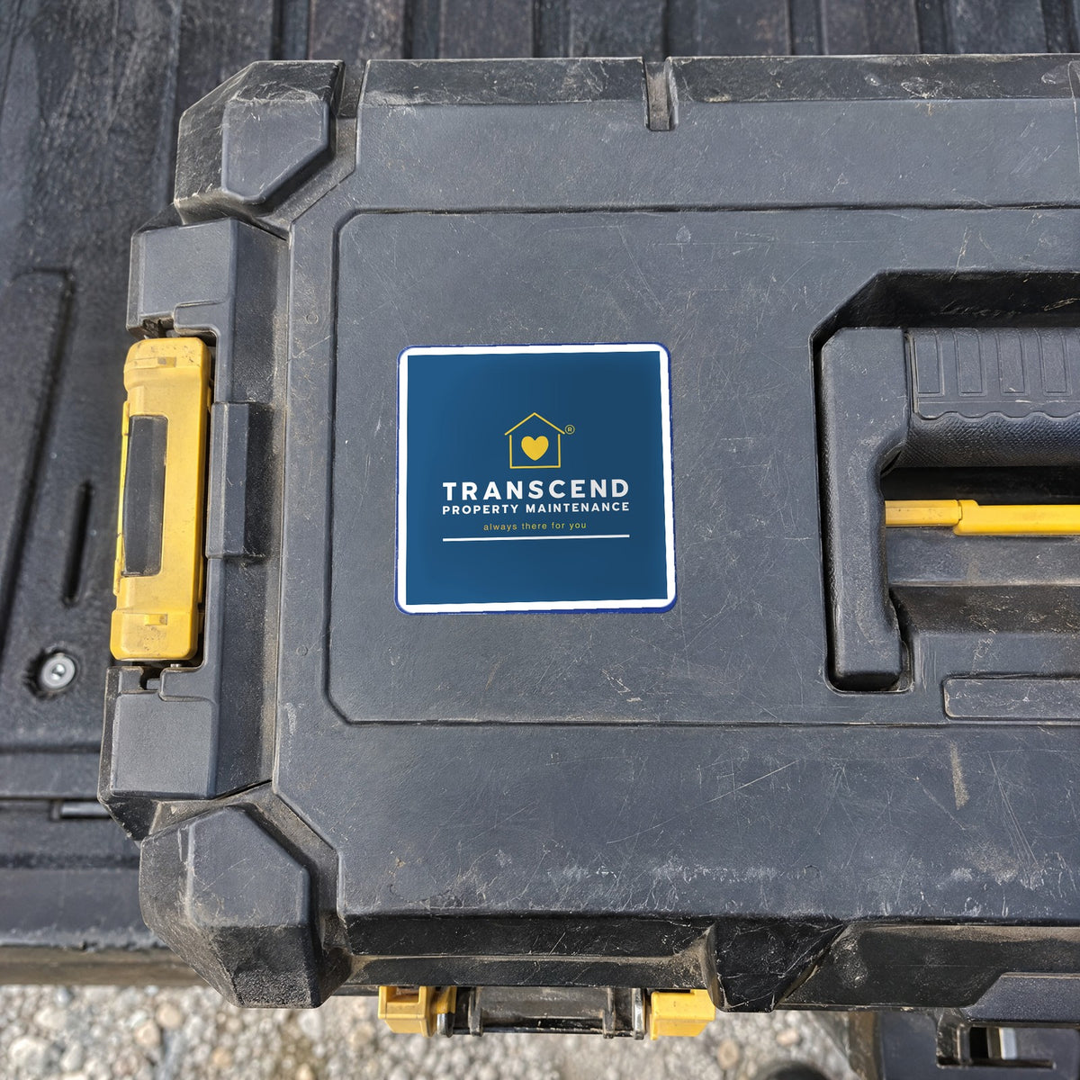 Transcend Property Maintenance logo sticker on a job-site tool box (AI-generated example scene, artwork placed from the real design)