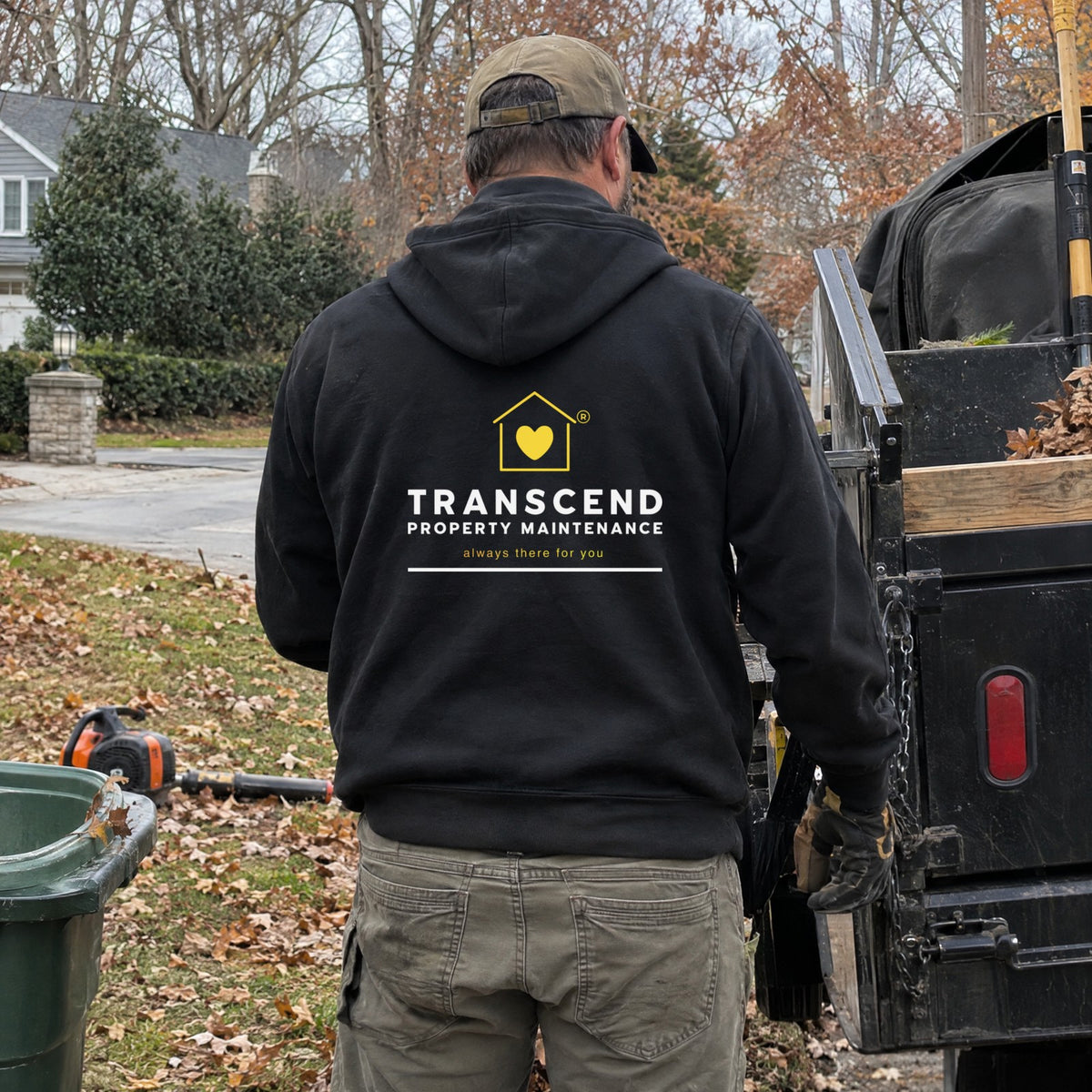 Back view of the Transcend Property Maintenance black full-zip hoodie with the logo on the back (AI-generated example photo, logo placement matched to the real product)