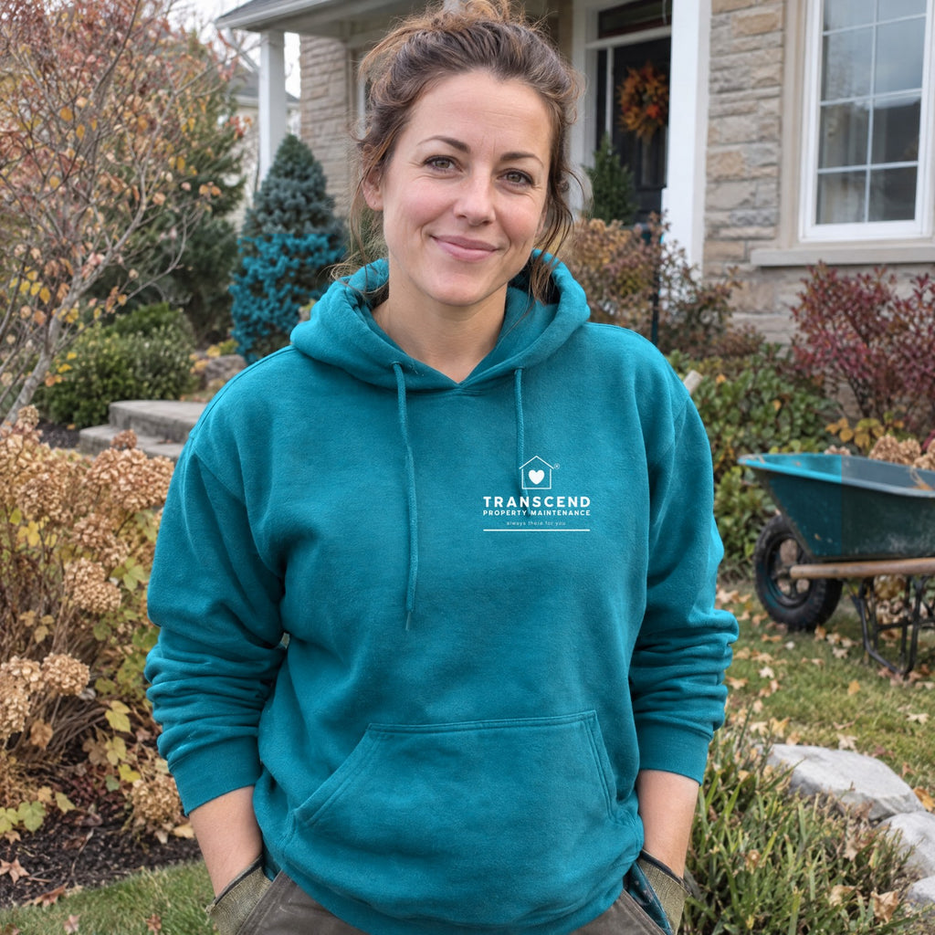 Landscaper wearing the Transcend Property Maintenance teal hoodie with the white logo on the left chest (AI-generated example photo, garment colour and logo placement matched to the real product)