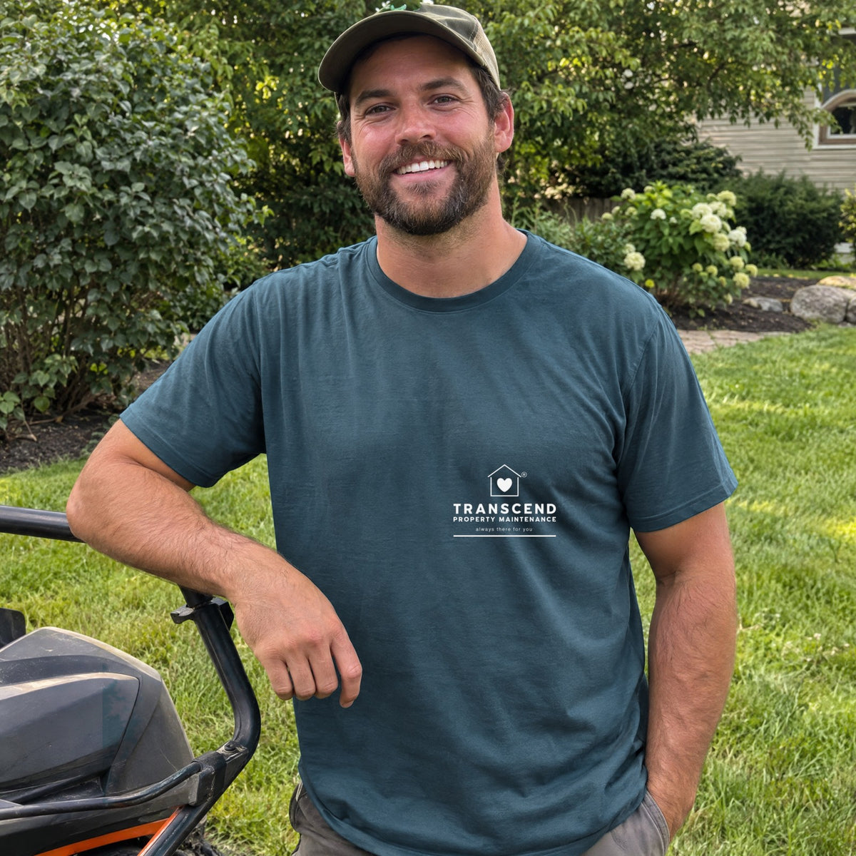 Landscaper wearing the Transcend Property Maintenance teal tee with the white logo on the left chest (AI-generated example photo, garment colour and logo placement matched to the real product)